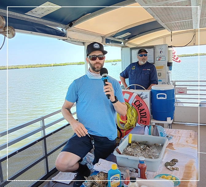 A man holding a microphone on top of a boat.