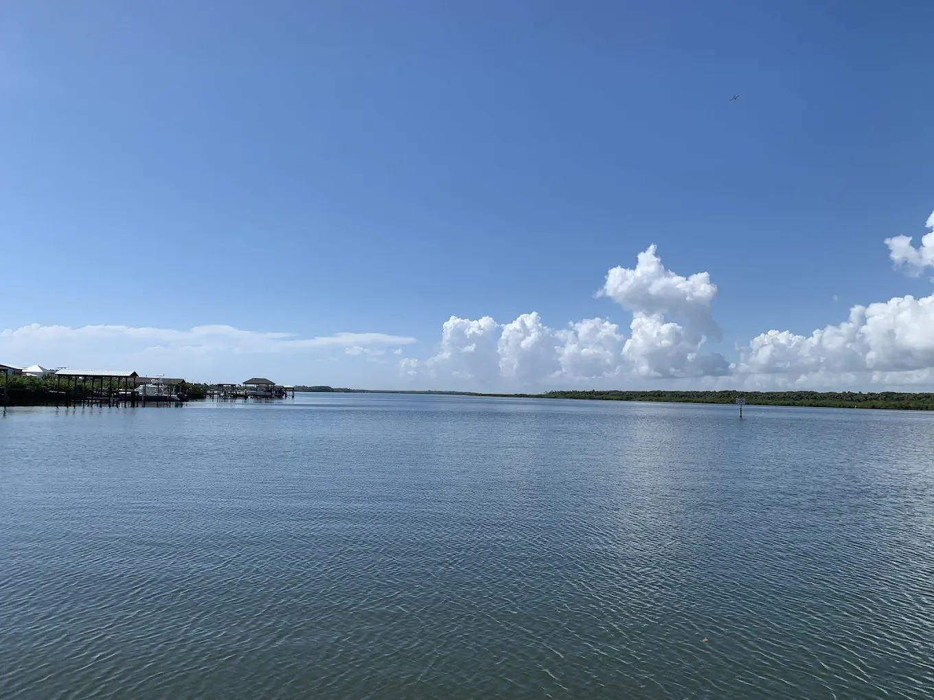 A body of water with clouds in the sky.