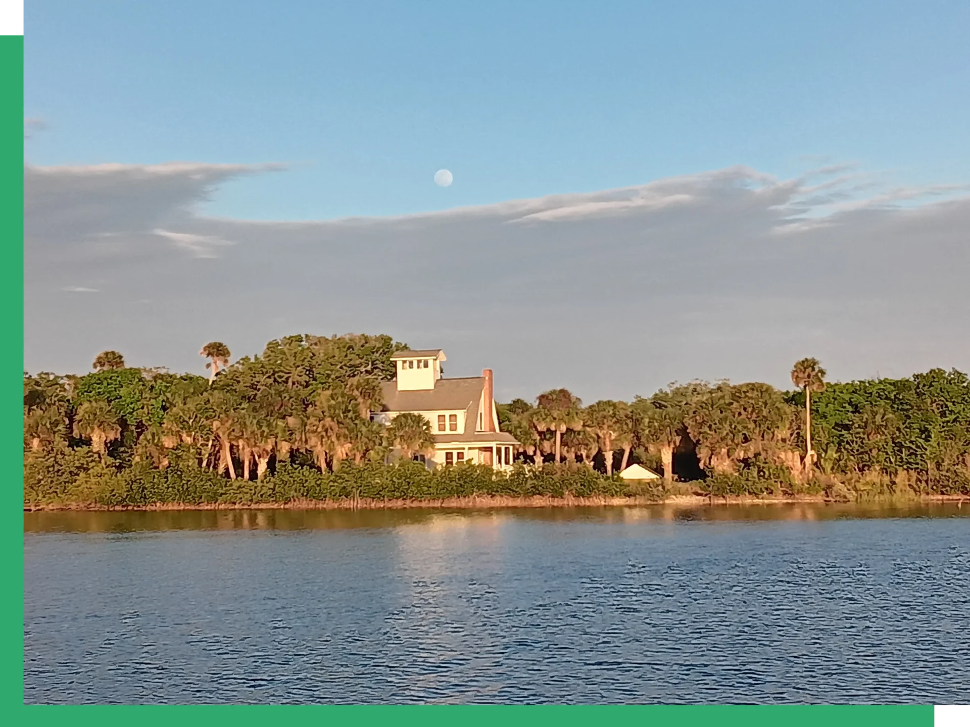 A house on the water with trees in front of it