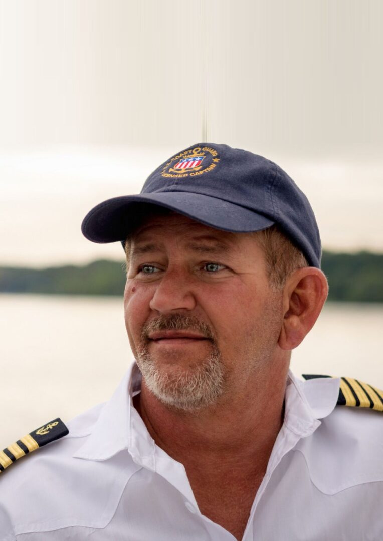 A man in a cap and uniform is looking at the camera.